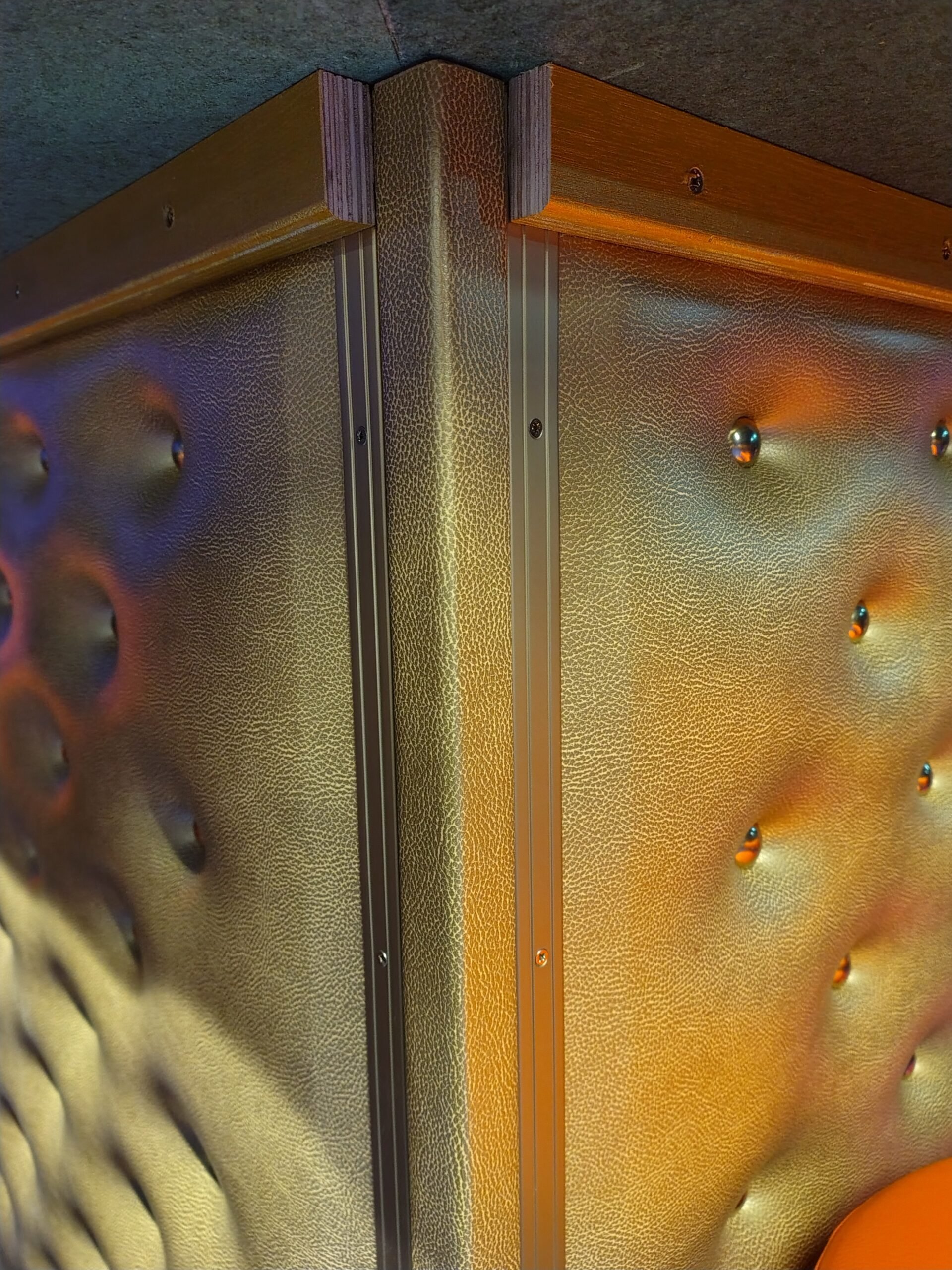 Hoek gestoffeerde wand met leerlook en metalen sierprofielen