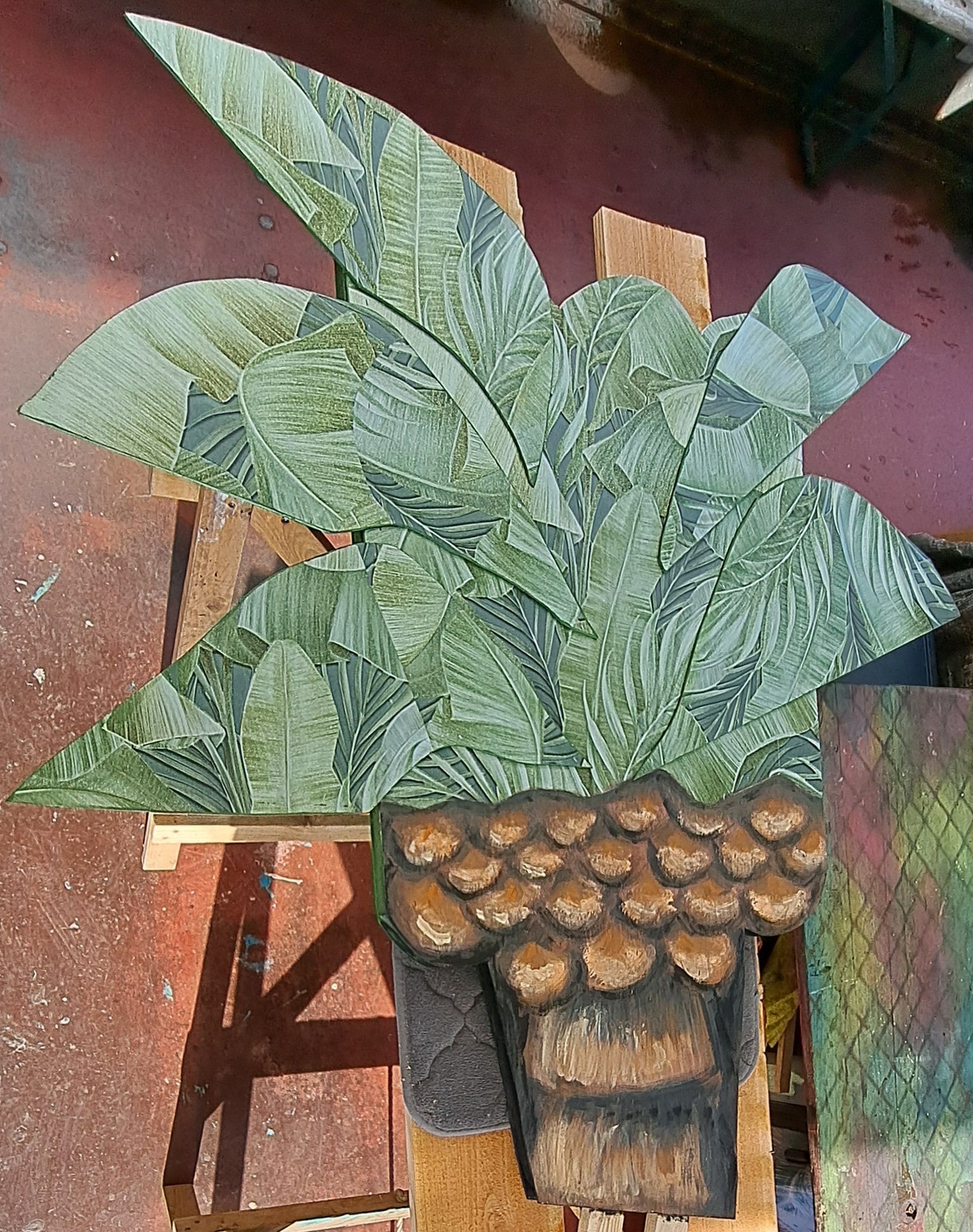 Houten kunstwerk met tropische bladeren